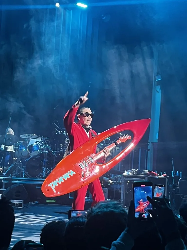 masayoshi takanaka on stage with a surfboard guitar